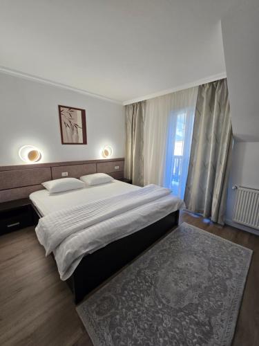 a bedroom with a large bed and a window at Vila CLASS in Vatra Dornei