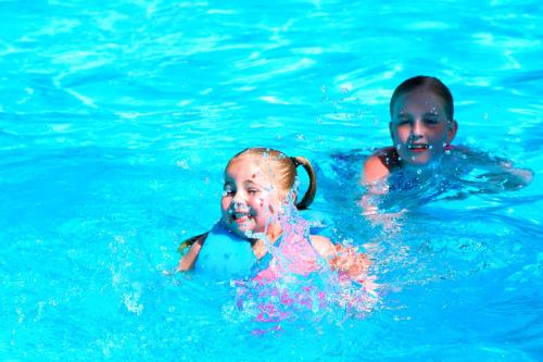 a boy and a girl swimming in the water at Geelong Surfcoast Hwy Holiday Park in Mount Duneed