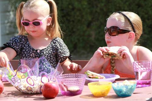 two young girls sitting at a table eating food at Geelong Surfcoast Hwy Holiday Park in Mount Duneed