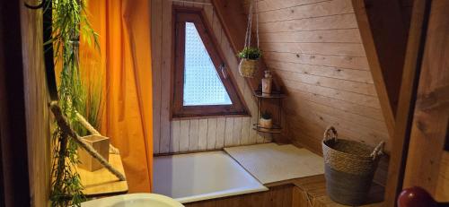 a bathroom with a bath tub and a window at Chalet Fontaine 54 in Ustou