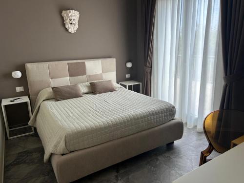 a bedroom with a bed and a mask on the wall at Villa Iulia Hills in Fiumefreddo di Sicilia
