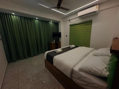a bedroom with a large bed with a green door at Mahadeva Residency in Trivandrum