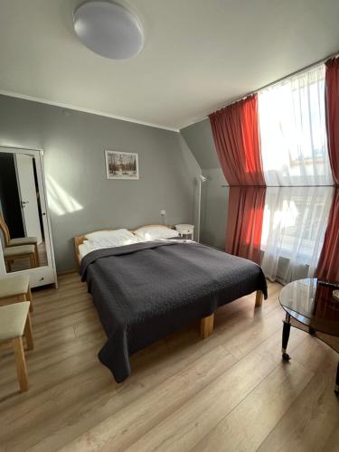 ein Schlafzimmer mit einem Bett, einem Tisch und einem Fenster in der Unterkunft Hotel Melturi in Melturi