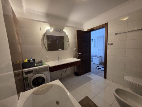 a bathroom with a sink and a washing machine at Tudor S Residence Mamaia in Văleni
