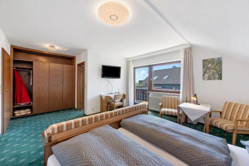 a hotel room with a bed and a television at Gästehaus Brigitte in Freudenstadt