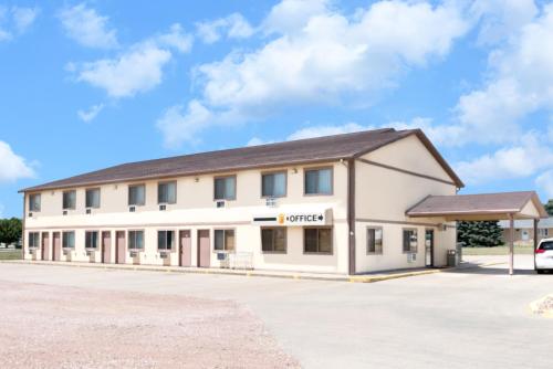 a large white building with a parking lot at Super 8 by Wyndham Winner SD in Winner