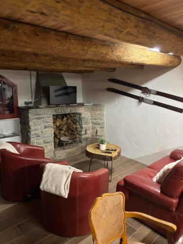 a living room with couches and a stone fireplace at Grange aménagée in Campan
