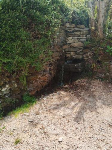 a stone wall next to a dirt road at Grange aménagée in Campan