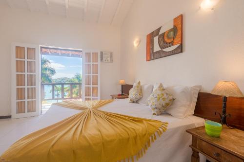 a bedroom with a large bed with yellow sheets at La Boheme Hotel e Apart Hotel in Búzios