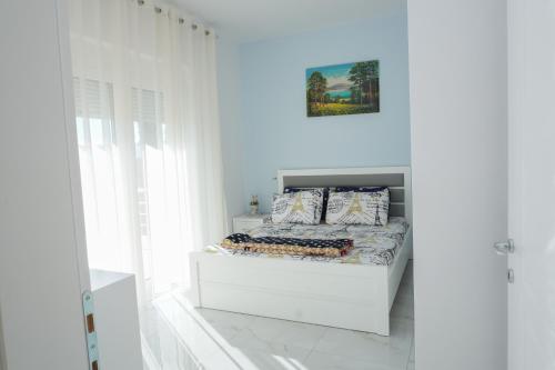 a white bedroom with a bed in a white wall at Vila Kabashi in Korçë