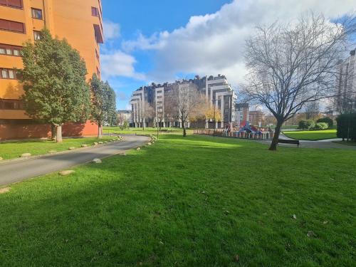 a park with green grass and buildings and a street at Ca'Oviedo in Oviedo