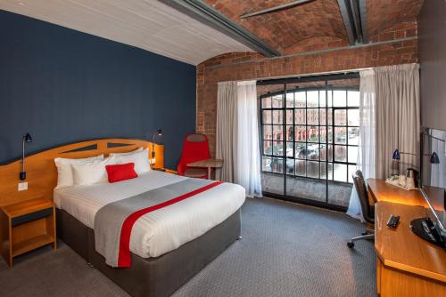 a bedroom with a bed and a desk and a window at Holiday Inn Express Liverpool-Albert Dock by IHG in Liverpool