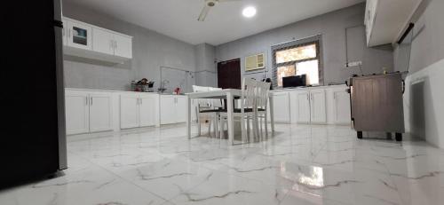 a kitchen with white cabinets and a table in it at Waterfront in Muscat