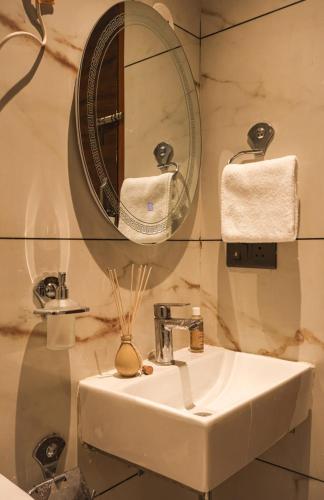 a bathroom with a sink and a mirror at The Glam By Sandane Homes in Greater Noida
