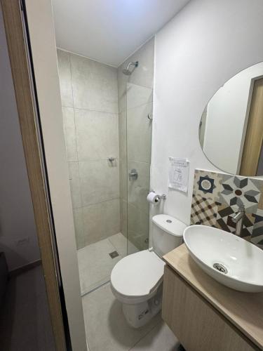 a bathroom with a toilet and a sink and a mirror at HOTElES SAN ANTONIO in Cali