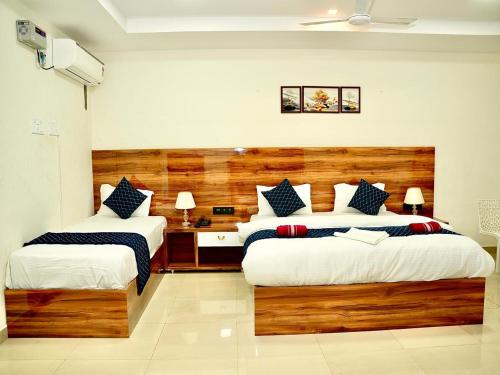 a bedroom with two beds and a desk in it at IRCTC Hotel HOSPET in Hospet