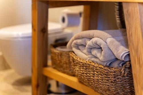 a basket of towels on a shelf next to a toilet at Cook's Club Adakoy, Marmaris - Adults Only "Plus 16" in Marmaris