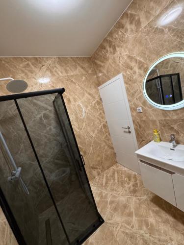 a bathroom with a shower and a sink and a mirror at Apartman CITY CENTER 9 BAZEN in Prijedor