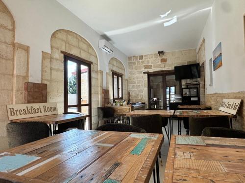 a restaurant with wooden tables and chairs in a room at Villa Oronzo in Torre Lapillo