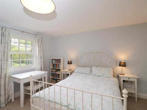 a bedroom with a bed and a desk and a window at Ormiston House in Pewsey