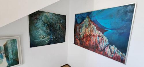 three paintings are hanging on a wall at Artist Apartment in Keszthely