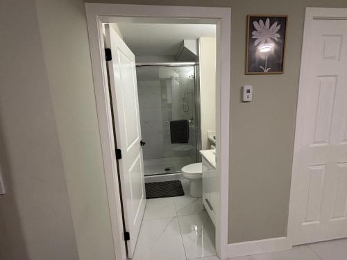 a white bathroom with a toilet and a sink at Private Bachelor Suite Near PNE in Vancouver