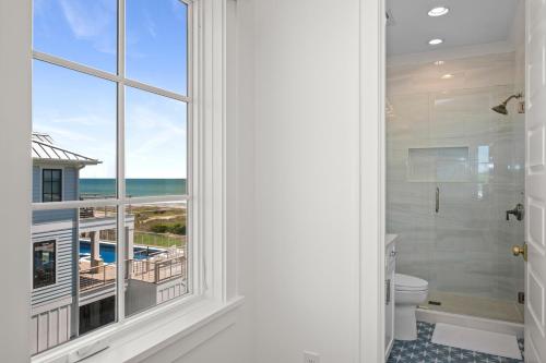 a bathroom with a window with a view of the ocean at Roosevelt Oceanfront Escape by Emerald Isle Realty in Pine Knoll Shores