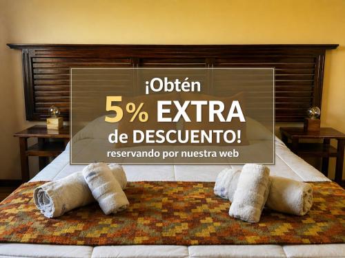 a sign on a bed with four pillows on it at Patagonia Austral Suites - Cabaña con servicio de hotel - DESAYUNO INCLUIDO! in El Calafate