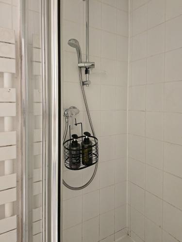 a bathroom with a shower with a basket on the wall at Le Michelet - Loft Cosy avec soirée cinéma Proche Vincennes in Montreuil