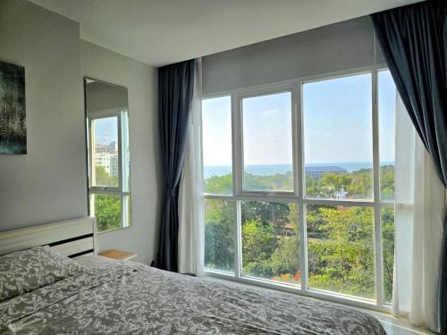 a bedroom with a bed and a large window at One Tower 84 by ThaiminatorPattaya in Pattaya South