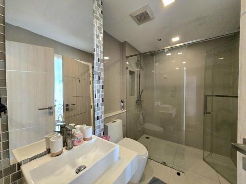 a bathroom with a sink and a toilet and a shower at One Tower 84 by ThaiminatorPattaya in Pattaya South