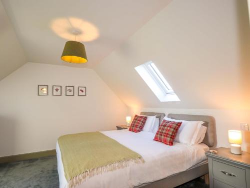 a bedroom with a white bed with two pillows at The Mandrel in Tain
