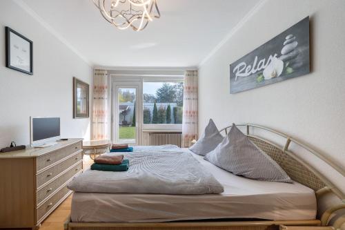 a bedroom with a bed and a television and a window at Ferienhaus an der Luhe 150 M² in Winsen