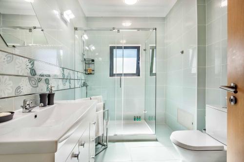 a bathroom with a shower and a sink and a toilet at Villa Vivienda Jade in Galé