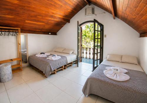 a bedroom with two beds in a room with a window at Nova Perola de Guaruja in Guarujá