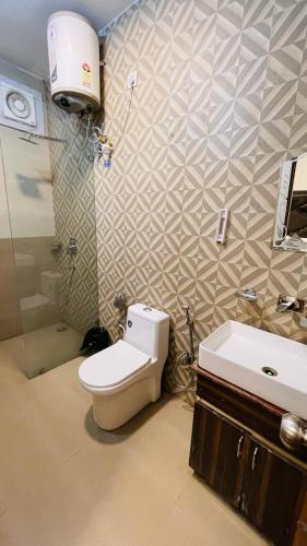 a bathroom with a toilet and a sink at Vantara Premium, Haridwar- with swimming Pool in Haridwār