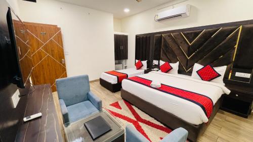 a bedroom with two beds and a desk and a chair at Vantara Premium, Haridwar- with swimming Pool in Haridwār
