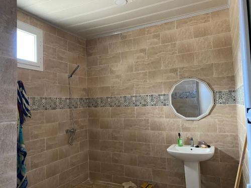 a bathroom with a sink and a mirror at villa larhat vue sur mer in Larhat