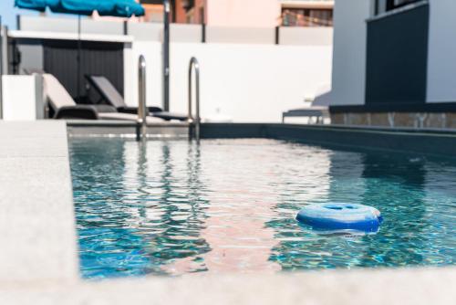 a swimming pool with a blue object in the water at Casa Caravelas - Matias Village in Praia da Areia Branca