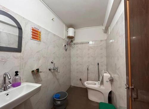 a bathroom with a white toilet and a sink at The Boho Darjeeling Stays in Darjeeling