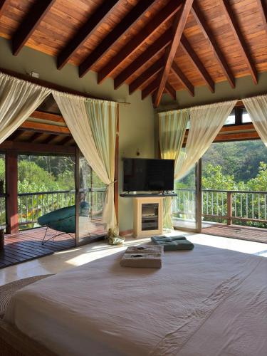 a bedroom with a large bed with a flat screen tv at La Laguna in Saboga