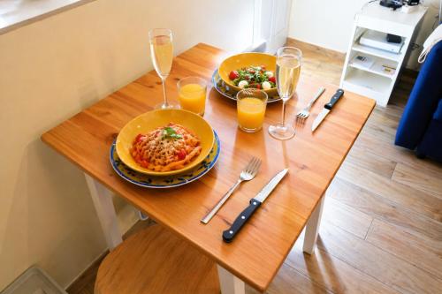 a table with two plates of food and glasses of orange juice at Studio cosy & bien équipé in Brétigny-sur-Orge