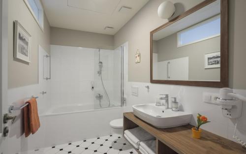 a white bathroom with a sink and a shower at SeNo6 Apartments in Prague