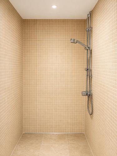 a bathroom with a shower with tiled walls at The Olive in Market Rasen