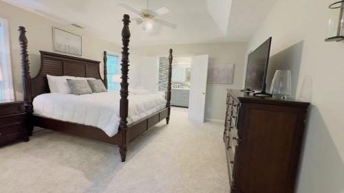 a bedroom with a bed and a dresser with a television at Dalby Way in Austell