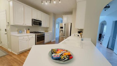 a kitchen with white cabinets and a bowl on the counter at Dalby Way in Austell