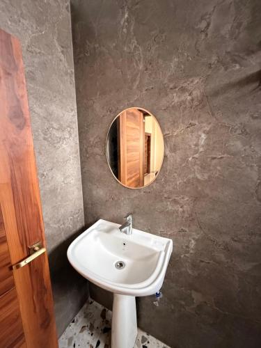 a bathroom with a sink and a mirror at The Lavish Landmark in Jorhat