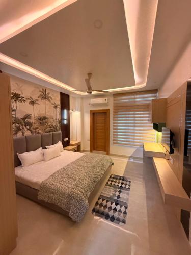 a bedroom with a large bed and a television at The Lavish Landmark in Jorhat