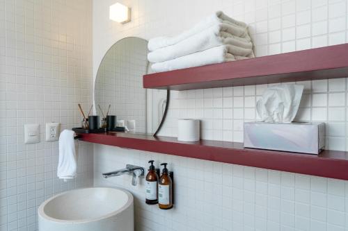 a bathroom with a sink and a shelf with towels at Casa Amari in Mexico City