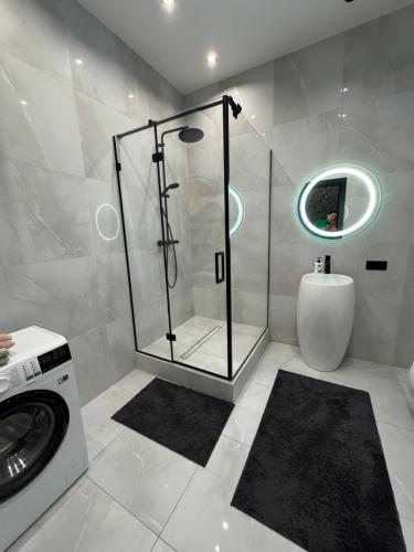 a bathroom with a shower and a washing machine at Delmar Apartment Center in Dnipro